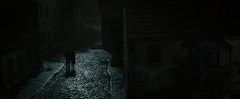 Movie still from “The Book Thief” (2013), directed by Brian Percival – A person walking down a street in the dark; Extreme Wide shot, High angle