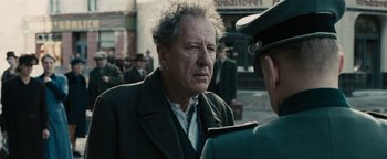Movie still from “The Book Thief” (2013), directed by Brian Percival – An older man is talking to a man in a uniform; Close Up shot, Over the shoulder angle