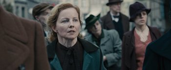 Movie still from “The Book Thief” (2013), directed by Brian Percival – An older woman wearing a green coat and a green hat; Close Up shot, Over the shoulder angle