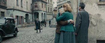 Movie still from “The Book Thief” (2013), directed by Brian Percival – Two women are hugging on a cobblestone street; Wide shot, Over the shoulder angle