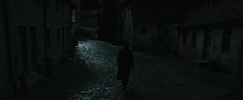 Movie still from “The Book Thief” (2013), directed by Brian Percival – A person walking down a street at night; Wide shot, High angle