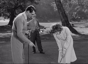Movie still from “Bringing Up Baby” (1938), directed by Howard Hawks – A man and a woman playing golf with a man holding a golf club; Medium shot, Over the shoulder angle