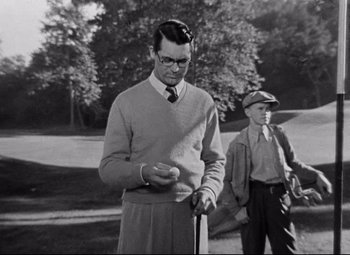 Movie still from “Bringing Up Baby” (1938), directed by Howard Hawks – A man holding a golf club while standing next to another man; Medium shot, Over the shoulder angle