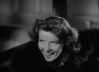Movie still from “Bringing Up Baby” (1938), directed by Howard Hawks – An old photo of a woman smiling for the camera; Close Up shot, Low angle