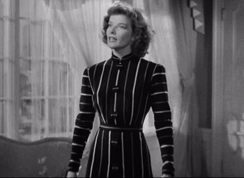 Movie still from “Bringing Up Baby” (1938), directed by Howard Hawks – A black and white photo of a woman in a striped dress; Medium shot, Low angle