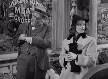 Movie still from “Bringing Up Baby” (1938), directed by Howard Hawks – An old photo of a man and a woman holding a cat; Medium shot, Over the shoulder angle