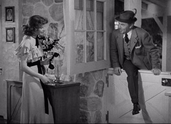 Movie still from “Bringing Up Baby” (1938), directed by Howard Hawks – An old photo of a man and a woman in front of a door; Wide shot, Low angle