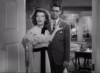 Movie still from “Bringing Up Baby” (1938), directed by Howard Hawks – A man and a woman standing next to each other in a room; Medium shot, Over the shoulder angle