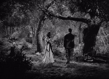 Movie still from “Bringing Up Baby” (1938), directed by Howard Hawks – A man and a woman walking through the woods; Wide shot, High angle