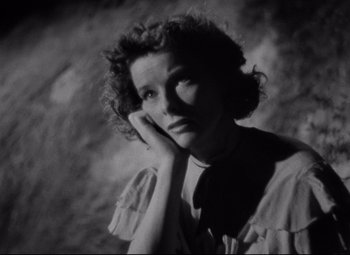 Movie still from “Bringing Up Baby” (1938), directed by Howard Hawks – An old black and white photo of a woman looking at the camera; Close Up shot, Low angle