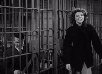 Movie still from “Bringing Up Baby” (1938), directed by Howard Hawks – A man and a woman standing in front of a jail cell; Medium shot, Low angle