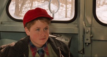 Movie still from “Broadcast News” (1987), directed by James L. Brooks – A young boy sitting on a train looking at the camera; Close Up shot, Over the shoulder angle