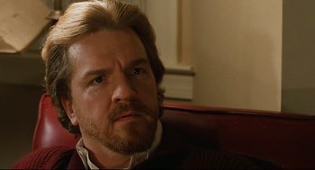 Movie still from “Broadcast News” (1987), directed by James L. Brooks – A person sitting on a couch; Close Up shot, Over the shoulder angle