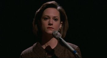 Movie still from “Broadcast News” (1987), directed by James L. Brooks – A woman is holding a microphone up to her face; Close Up shot, Low angle