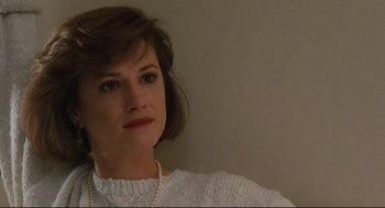 Movie still from “Broadcast News” (1987), directed by James L. Brooks – A person wearing a white sweater; Close Up shot, High angle