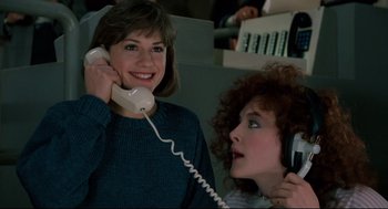 Movie still from “Broadcast News” (1987), directed by James L. Brooks – Two women are talking on the phone and smiling; Close Up shot, Low angle
