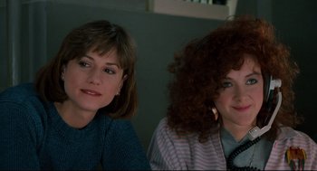 Movie still from “Broadcast News” (1987), directed by James L. Brooks – Two women sitting next to each other in front of a wall; Close Up shot, Low angle