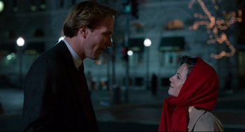 Movie still from “Broadcast News” (1987), directed by James L. Brooks – A man and a woman talking to each other on the street; Medium shot, Low angle