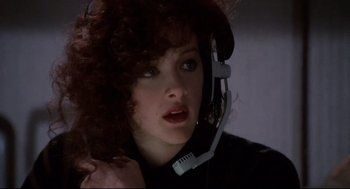 Movie still from “Broadcast News” (1987), directed by James L. Brooks – A woman wearing a headset and looking at the camera; Close Up shot, Low angle