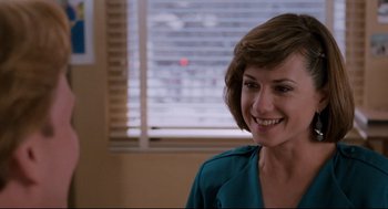 Movie still from “Broadcast News” (1987), directed by James L. Brooks – A woman smiling in front of a window with blinds; Close Up shot, Over the shoulder angle