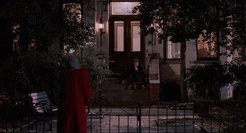 Movie still from “Broadcast News” (1987), directed by James L. Brooks – A woman sitting on the steps of a house at night; Wide shot, Over the shoulder angle
