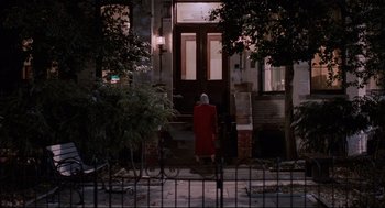 Movie still from “Broadcast News” (1987), directed by James L. Brooks – An older woman in a red coat walking down the street; Extreme Wide shot, Over the shoulder angle