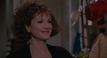 Movie still from “Broadcast News” (1987), directed by James L. Brooks – A person with curly hair smiling; Close Up shot, Over the shoulder angle