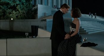 Movie still from “Broadcast News” (1987), directed by James L. Brooks – A man and a woman standing next to each other in front of a building; Medium shot, Low angle