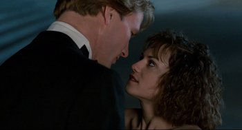 Movie still from “Broadcast News” (1987), directed by James L. Brooks – A man and a woman face to face in front of a wall; Close Up shot, Low angle