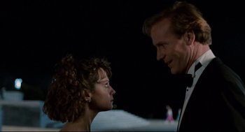 Movie still from “Broadcast News” (1987), directed by James L. Brooks – A man and a woman standing next to each other in front of a body of water at night; Close Up shot, Low angle