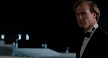 Movie still from “Broadcast News” (1987), directed by James L. Brooks – A man standing in the dark looking at the camera; Close Up shot, Low angle