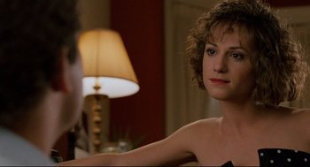 Movie still from “Broadcast News” (1987), directed by James L. Brooks – A woman sitting in front of a lamp in a living room; Close Up shot, Over the shoulder angle