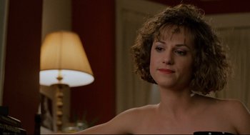 Movie still from “Broadcast News” (1987), directed by James L. Brooks – A beautiful woman with curly hair sitting in front of a lamp; Close Up shot, Over the shoulder angle