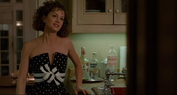 Movie still from “Broadcast News” (1987), directed by James L. Brooks – A woman standing in front of a kitchen sink; Medium shot, Over the shoulder angle