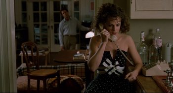 Movie still from “Broadcast News” (1987), directed by James L. Brooks – A woman in a polka dot dress talking on a phone; Medium shot, High angle