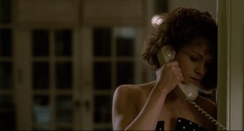 Movie still from “Broadcast News” (1987), directed by James L. Brooks – A person holding a cell phone to their ear; Close Up shot, Over the shoulder angle