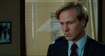 Movie still from “Broadcast News” (1987), directed by James L. Brooks – A person wearing a suit and tie; Close Up shot, Over the shoulder angle
