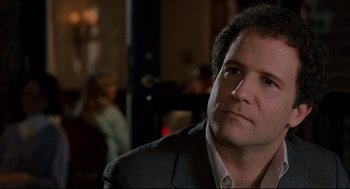 Movie still from “Broadcast News” (1987), directed by James L. Brooks – A person wearing a suit and tie; Close Up shot, Over the shoulder angle