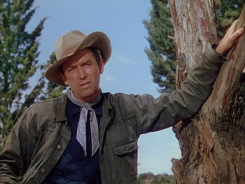 Movie still from “Broken Arrow” (1950), directed by Delmer Daves – A man leaning against a tree wearing a cowboy hat; Medium shot, Low angle