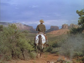 Movie still from “Broken Arrow” (1950), directed by Delmer Daves – A man riding a horse through the desert; Wide shot, Low angle