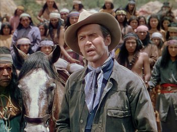 Movie still from “Broken Arrow” (1950), directed by Delmer Daves – A man standing in front of a group of people and a horse; Medium shot, Over the shoulder angle