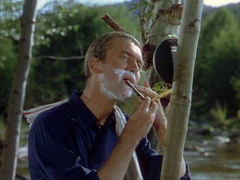 Movie still from “Broken Arrow” (1950), directed by Delmer Daves – A man with a shaving cream on his face is brushing his teeth; Medium shot, Over the shoulder angle