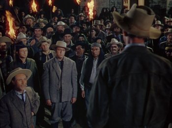 Movie still from “Broken Arrow” (1950), directed by Delmer Daves – A group of men standing next to each other in a room; Wide shot, High angle