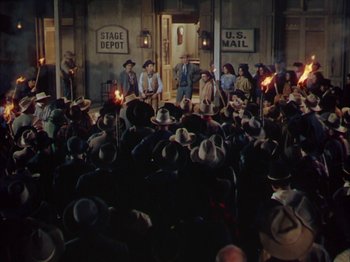 Movie still from “Broken Arrow” (1950), directed by Delmer Daves – A group of people in a room with hats on; Extreme Wide shot, High angle