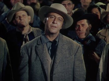 Movie still from “Broken Arrow” (1950), directed by Delmer Daves – A man in a suit and a hat; Close Up shot, Over the shoulder angle