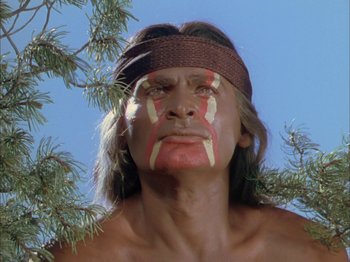 Movie still from “Broken Arrow” (1950), directed by Delmer Daves – A man with face paint standing next to a tree; Close Up shot, Low angle