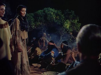 Movie still from “Broken Arrow” (1950), directed by Delmer Daves – A group of native americans gathered around a campfire; Medium shot, Over the shoulder angle