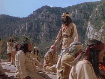 Movie still from “Broken Arrow” (1950), directed by Delmer Daves – A group of people sitting on the ground in native dress; Wide shot, High angle