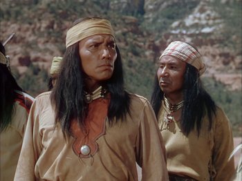 Movie still from “Broken Arrow” (1950), directed by Delmer Daves – Two native american men standing next to each other; Medium shot, Over the shoulder angle