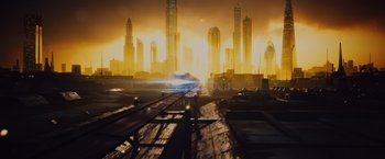 Movie still from “Broken City” (2013), directed by Allen Hughes – A car driving down a street in front of a city skyline; Extreme Wide shot, Low angle